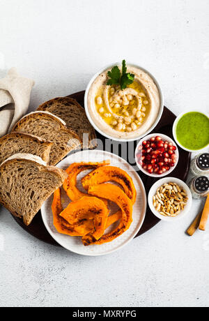 vegan appetizer snack from hummus of white cannellini beans and baked pumpkin with Rye bread on a serving board. Just great food Stock Photo