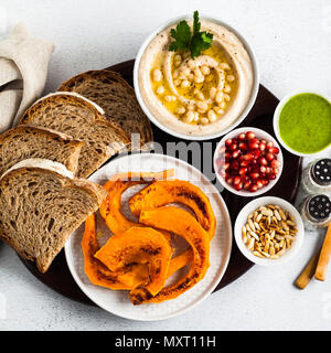 vegan appetizer snack from hummus of white cannellini beans and baked pumpkin with Rye bread on a serving board. Just great food Stock Photo