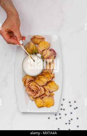 Beautiful white flat lay with a candle and dried rose petals. Top view, white background, flat lay concept Stock Photo