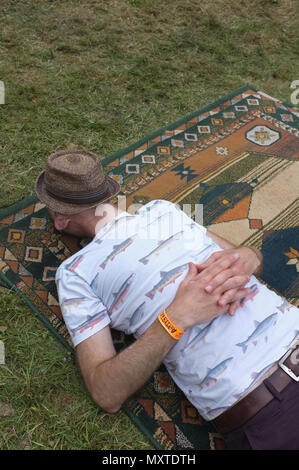 A man asleep at a festival Stock Photo