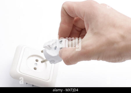 close up of a hand including a fork in an electrical outlet. Stock Photo