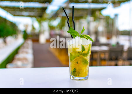 a chilled lime green mojito cocktail on a rooftop bar Stock Photo