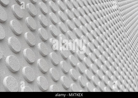 Textured wall in symetrical circular embossed shapes repeating, light grey color. Stock Photo