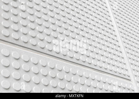 Textured wall in symetrical circular embossed shapes repeating, light grey color. Stock Photo