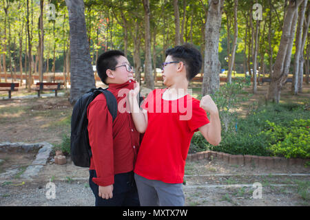 Young boy students fighting  in the park Stock Photo