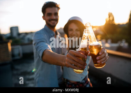 Young happy couple toasting with beer outdoors Stock Photo
