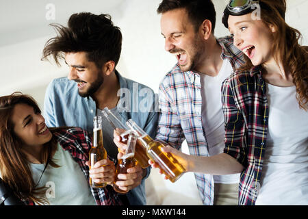 Group of happy young friends having fun and drinking beer