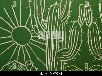A scene with cactus and sun is drawing with chalk on a chalkboard. Stock Photo