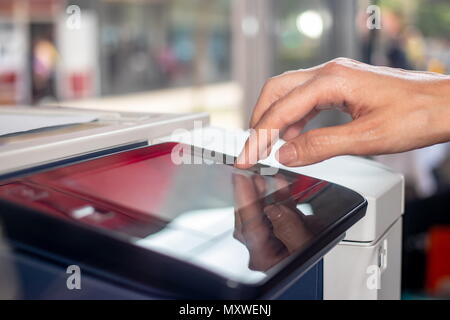 Woman's hand working on the copier's touchscreen in a copy center Stock Photo
