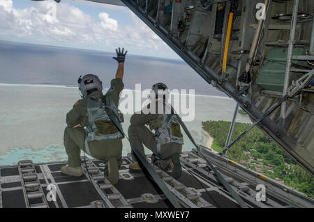 161211-N-YM720-078  FEDERATED STATES OF MICRONESIA (Dec. 12, 2016) – A loadmaster attached to the 36th Airlift Squadron, Yokota Air Base, Japan, waves to the natives of a Micronesian island after dropping off care packages during Operation Christmas Drop, Dec. 11.  Operation Christmas Drop is an international humanitarian operation that provides critical supplies to 56 islands through the Commonwealth of the Northern Marianas, Federated States of Micronesia and Republic of Palau, impacting about 20,000 people. (U.S. Navy photo by Petty Officer 2nd Class Allen Michael McNair/Released) Stock Photo