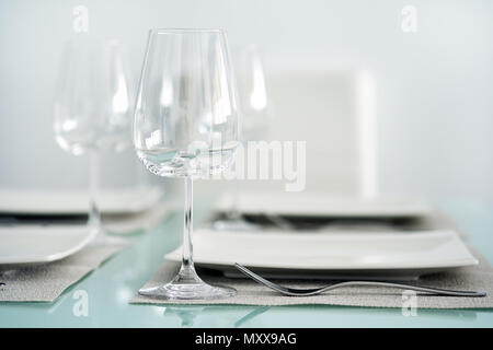 Table setting with a wine glasses, cutlery and plates Stock Photo