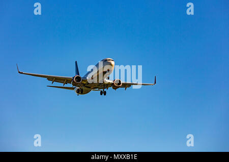 Large passenger plane flying in the blue sky Stock Photo