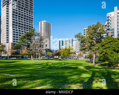 Green grass at historic Flagstaff Gardens in Melbourne's CBD. Spacious public park against high-rise modern buildings in city centre. VIC Australia Stock Photo