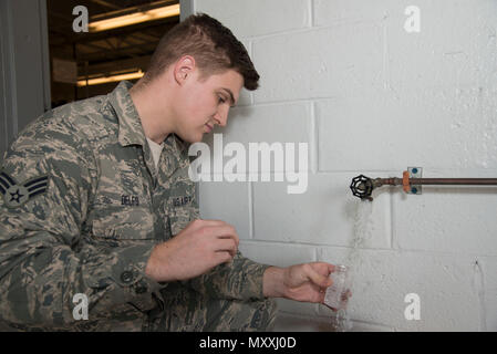 Senior Airman Alexander Delfs, 436th Aerospace Medicine Squadron bioenvironmental engineering journeyman, collects a water sample for bacteriologic testing Nov. 16, 2016, at an aircraft watering point on Dover Air Force Base, Del. Members of the 436th AMDS bioenvironmental engineering flight send water samples to a laboratory to test for the presence of harmful bacteria in drinking water. (U.S. Air Force photo by Senior Airman Aaron J. Jenne) Stock Photo