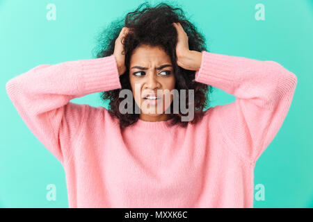 Image closeup of distressed woman with headache grabbing head and expressing pain isolated over blue background Stock Photo