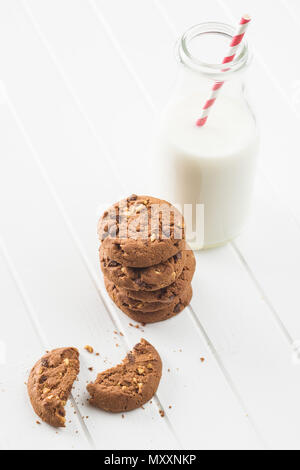 Tasty chocolate cookies and milk on white table. Stock Photo
