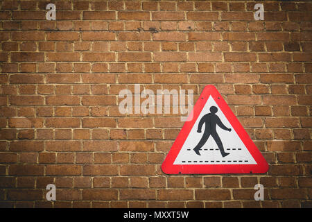 Vintage pedestrian crossing sign on a brick wall background. Landscape format. Stock Photo