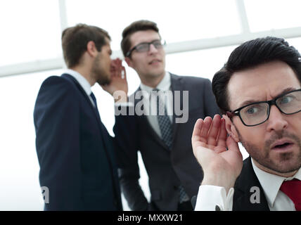 close up.businessman eavesdropping on conversation between colleagues Stock Photo