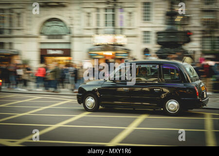 London, UK - October 2017. Taxi in Piccadilly Circus. Black cabs are the most iconic symbol of London as well as Red Double Decker Buses. Stock Photo