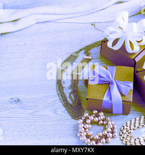 Surrealism gift boxes with gifts. Women's jewelry on a light wooden background. Stock Photo