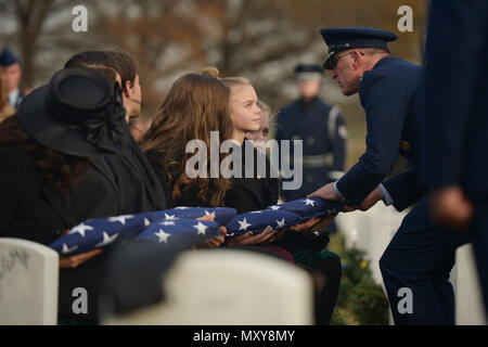 U.S. Air Force Maj. Gen. Scott Vander Hamm, Air Force assistant deputy chief of staff of operations, presents a flag to Annalise during the interment for her father, U.S. Air Force Maj. Troy Gilbert, at Arlington National Cemetery Dec. 19, 2016.  He is survived by his mother and father, Kaye and retired Senior Master Sgt. Ron Gilbert; sister, Rhonda Jimmerson; wife, Ginger Gilbert Ravella; sons, Boston and Greyson; and daughters, Isabella, Aspen and Annalise. (U.S. Air Force photo/ Tech. Sgt. Joshua DeMotts) Stock Photo