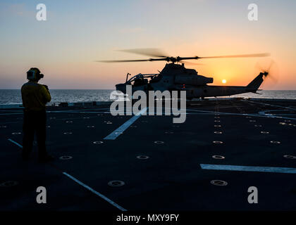 161213-N-LR795-114 GULF OF ADEN (Dec. 13, 2016) An AH-1 Cobra prepares to launch off the flight deck of the amphibious transport dock ship USS Somerset (LPD 25) during Exercise Alligator Dagger. The unilateral exercise is designed to provide an opportunity for the Makin Island Amphibious Ready Group (ARG) and 11th Marine Expeditionary Unit to train in amphibious operations within the U.S. 5th Fleet area of operations. Somerset is deployed as part of the Makin Island (ARG) to the U.S. 5th Fleet area of operations to support maritime security operations and theater security cooperation efforts ( Stock Photo