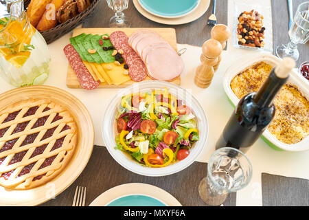 Top view of festive dinner table with delicious healthy food and homemade dishes, salad and pie on it, served with robin blue plates and napkins, copy Stock Photo