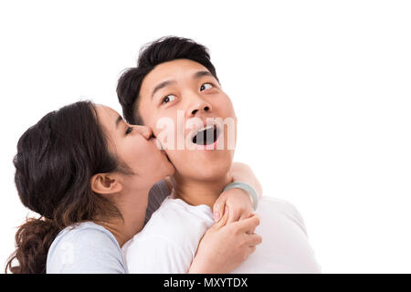 Kiss On the Cheek. Surprised young man getting a kiss from girlfriend. Stock Photo
