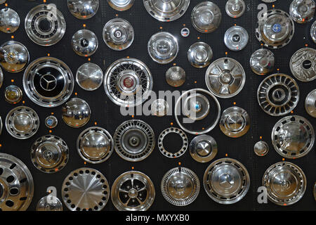 A variety of chrome hub caps in different shapes and sizes from different cars on a black background at the Shetland Classic Car show 2018 Stock Photo