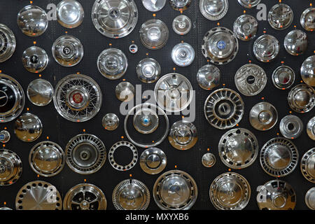 A variety of chrome hub caps in different shapes and sizes from different cars on a black background at the Shetland Classic Car show 2018 Stock Photo