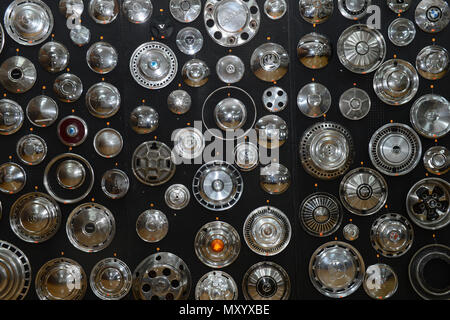 A variety of chrome hub caps in different shapes and sizes from different cars on a black background at the Shetland Classic Car show 2018 Stock Photo