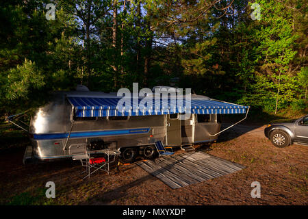 The iconic American made Airstream travel trailer sits in at a campsite at Driftwood Provincial Park in Ontario Canada. Airstream was founded in the l Stock Photo