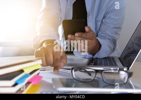businessman using phone smart phone and notebook computer Stock Photo