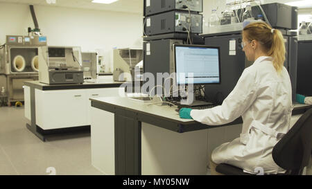 Scientists in the laboratory in front of computers do scientific research. Female researcher working on a computer in a laboratory. Stock Photo