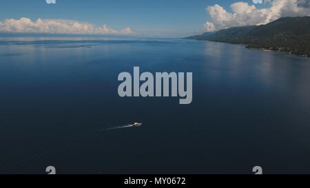 Aerial image of motorboat floating in a turquoise blue sea water. The ...