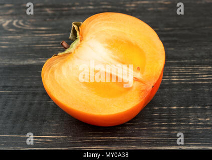 Half of juicy ripe fruit persimmon closeup on the table Stock Photo