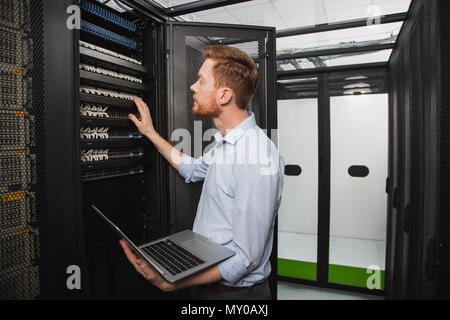 Handsome IT technician performing test Stock Photo