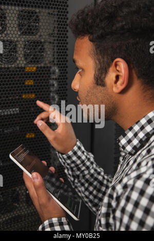 Pensive IT technician programming server Stock Photo