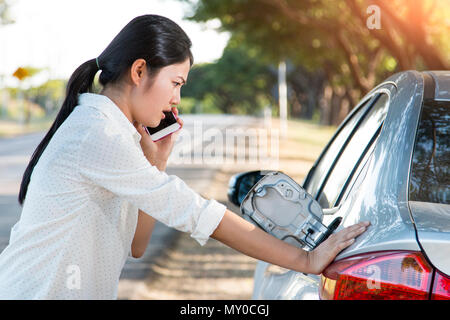 Car oil down and Young woman trying to calling for help on phone. Stock Photo