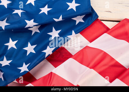 American satin flag close up. Stars and stripes flag. USA flag folded on white wood. Stock Photo