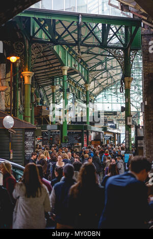 London, UK - November 2017. Tourists and shoppers in Borough Market, one of the largest and oldest food markets in London. Portrait format. Stock Photo