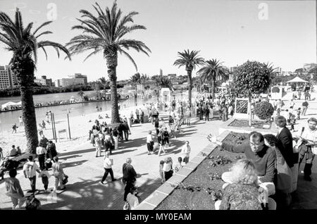 Southbank Beach, Brisbane, 1992. South Bank was originally a meeting place for the traditional landowners, the Turrbal and Yuggera people and, in the early 1840s it became the central focus point of early European settlement. From the 1850s, South Bank Precinct was quickly established as the business centre of Brisbane. However, this was all disrupted when the 1893 Brisbane floods forced the central business district to shift to the northern side of the river and attain higher ground. This is where the Brisbane central business district still stands today. This began the decline of South Bank, Stock Photo