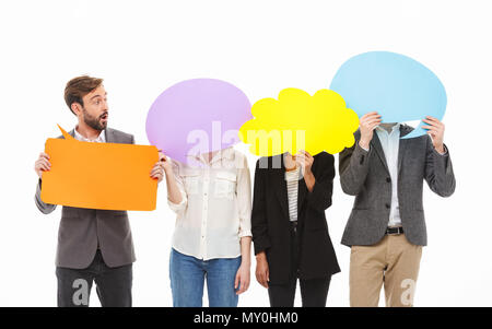 Portrait of a group of excited business people holding empty speech bubbles isolated over white background Stock Photo