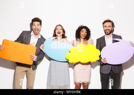 Group of an excited well dressed multiracial people holding empty speech bubbles isolated over white background Stock Photo