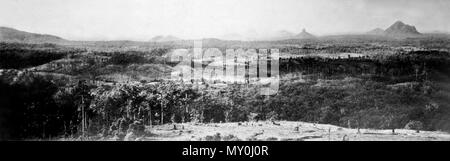 Glass House Mountains, c 1931. Glass House Mountains National Park  The volcanic peaks of the Glass House Mountains rise dramatically from the surrounding Sunshine Coast landscape. The Glass House Mountains were named by Lieutenant James Cook in 1770. The following extract from Cook's journal on Thursday, 17 May 1770 noted:  'These hills lie but a little way inland and not far from each other, they are very remarkable on account of their singular form elevation, which very much resemble glass houses which occasioned my g Stock Photo