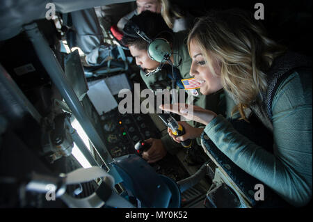 Emily Hagemeier, Team Shaw spouse, blows a kiss to her husband, Capt. Derek Hagemeier, 77th Fighter Squadron F-16CM Fighting Falcon pilot, during a collaborative refueling training and spouse flight event over the Atlantic Ocean, Dec. 21, 2016. Several Team Shaw spouses had the opportunity to watch from the aircraft’s rear window as their husbands approached the KC-135 Stratotanker, which was assigned to the 93rd Air Refueling Squadron from Farichild Air Force Base, Wash., to practice refueling procedures. (U.S. Air Force photo by Senior Airman Zade Vadnais) Stock Photo