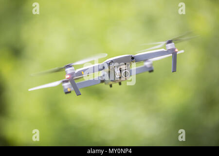 Close-up quadcopter drone with camera flying in park. Stock Photo