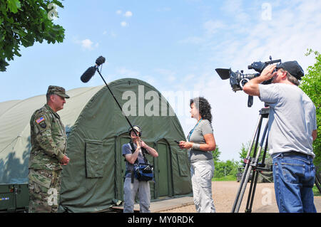 Brig. Gen. Clint E. Walker, commander, 184th Sustainment Command, being interviewed by Department of Logistics Agency, Nutan Chada,  on June 1, in Powidz, Poland about the relationship between 184th SC and DLA during Saber Strike 18. The Saber Strike exercises have had great success in creating a foundation for the strong relationships we share with several European allies and partners today. (Mississippi National Guard photo by Staff Sgt. Veronica McNabb, 184th Sustainment Command Public Affairs) Stock Photo