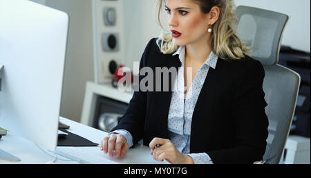 Overworked businesswoman staying in late Stock Photo