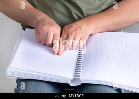 Blind man was reading a book written on Braille. Stock Photo